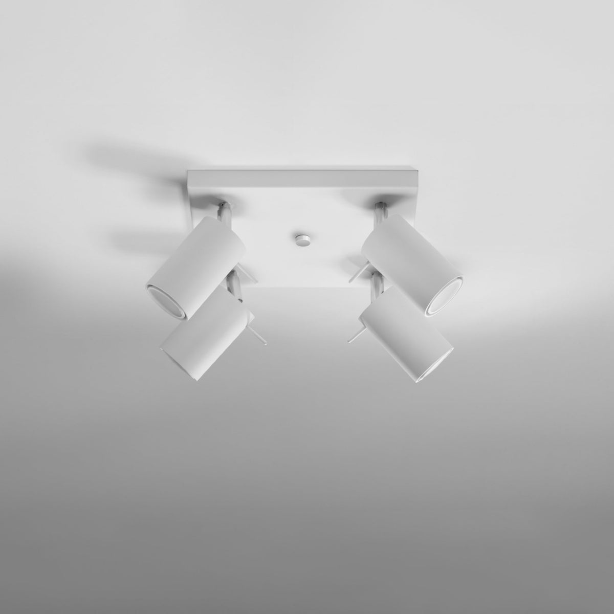 Luminaire fixé au plafond, quatre projecteurs cylindriques inclinés vers le bas