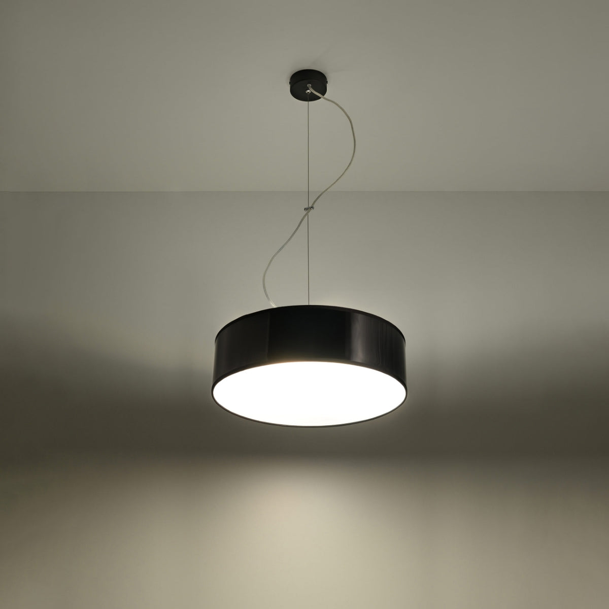 Abat-jour cylindrique allumé diffusant une lumière chaude dans une pièce sombre