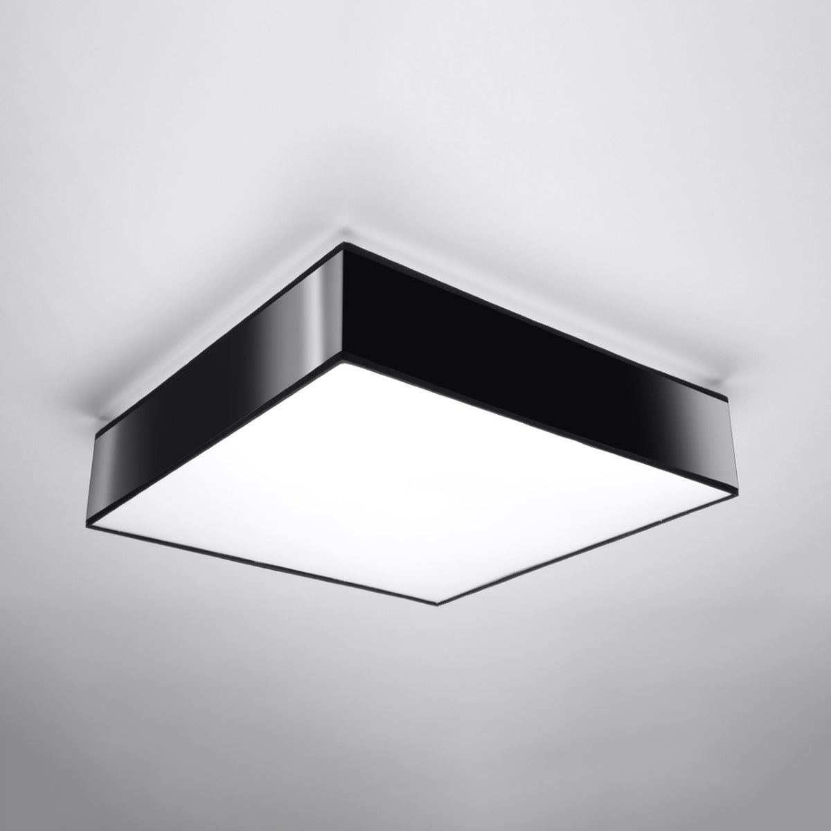 Vue du plafonnier carré monté au plafond, éteint, cadre noir et diffuseur blanc.
