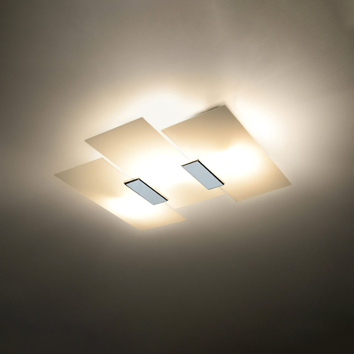 Luminaire allumé au plafond diffusant une lumière chaude dans une pièce sombre