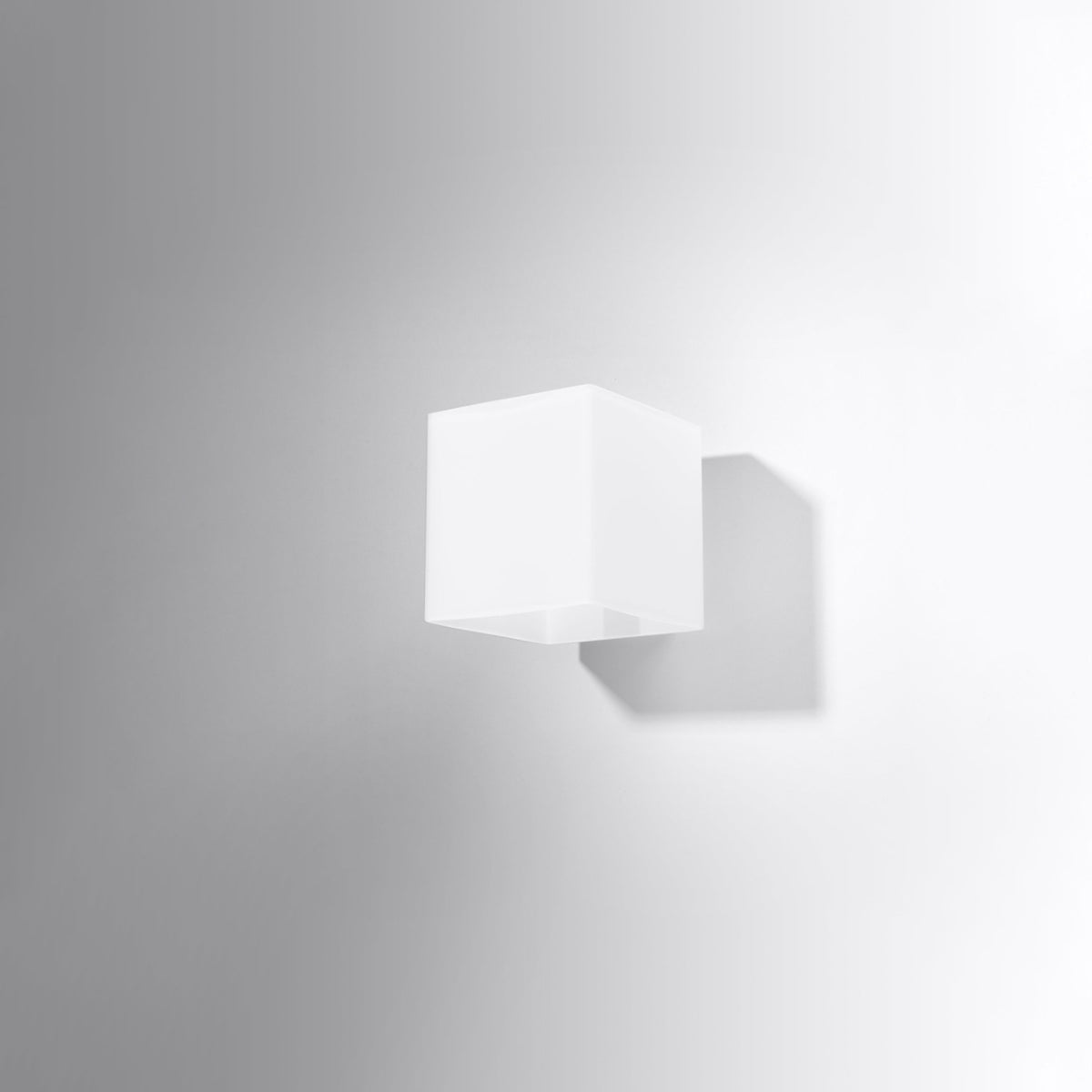 Applique blanche fixée sur un mur clair, ombre portée douce sous le boîtier