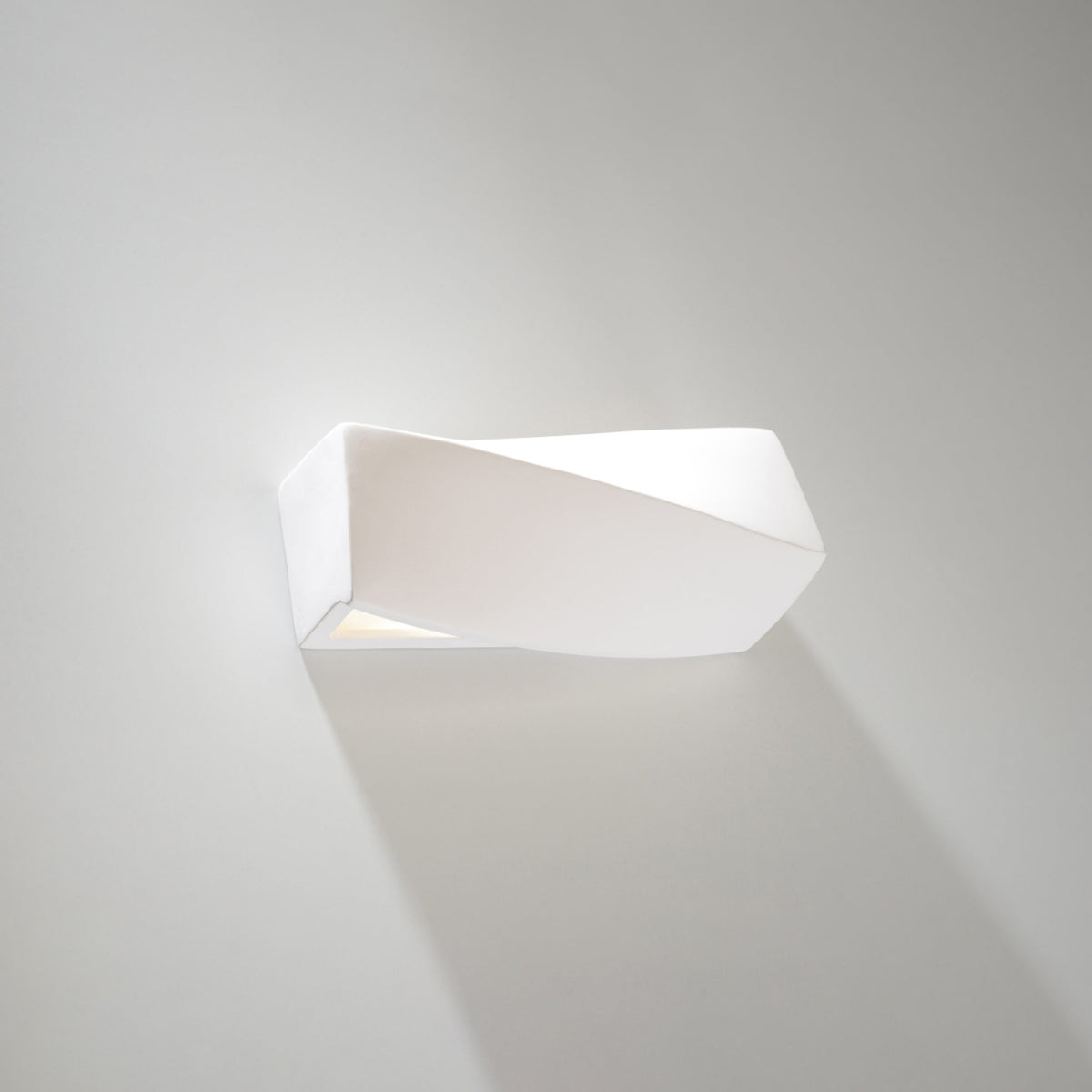 Même luminaire blanc fixé au mur, ombre portée douce sous le boîtier
