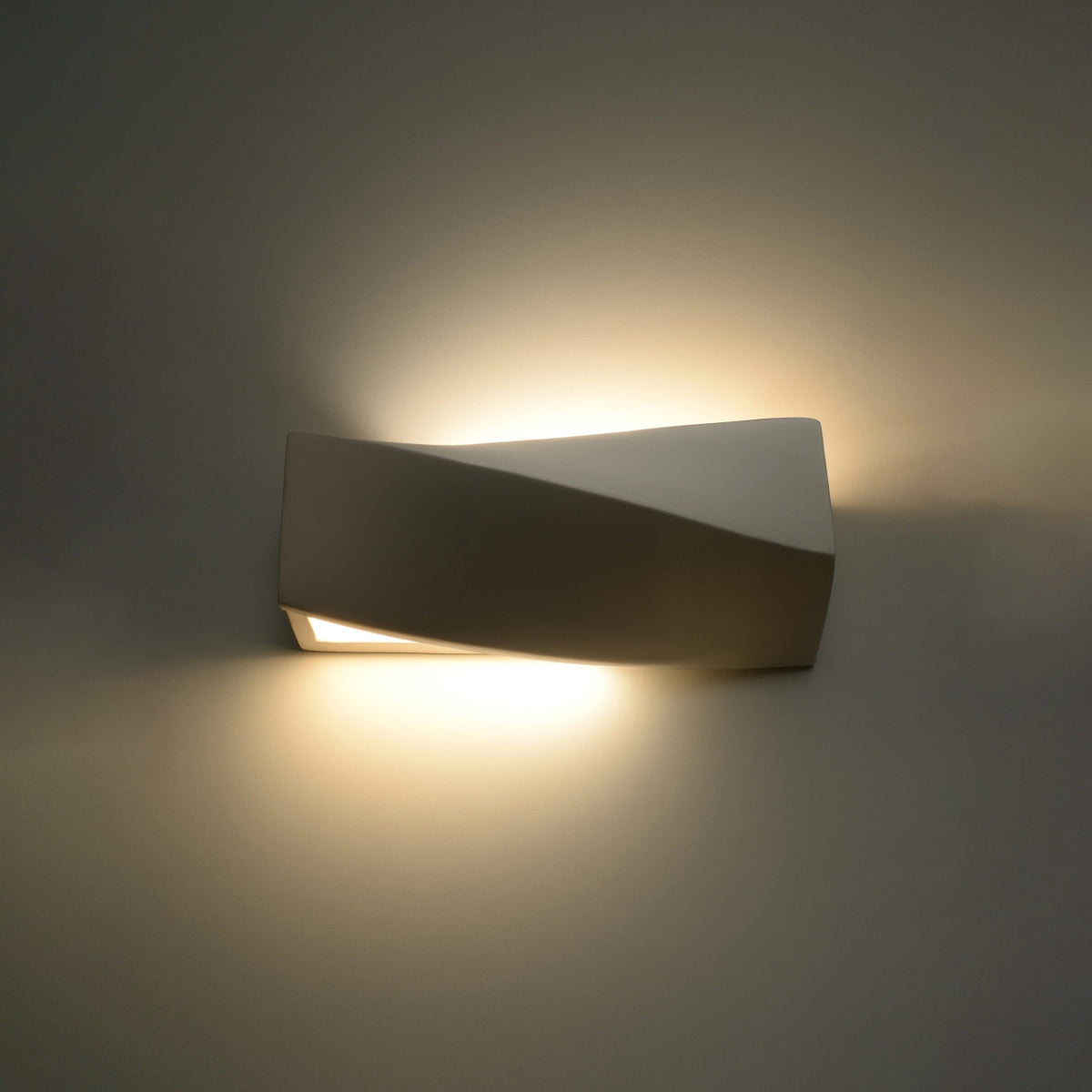Applique allumée projetant deux halos de lumière chaude en haut et en bas