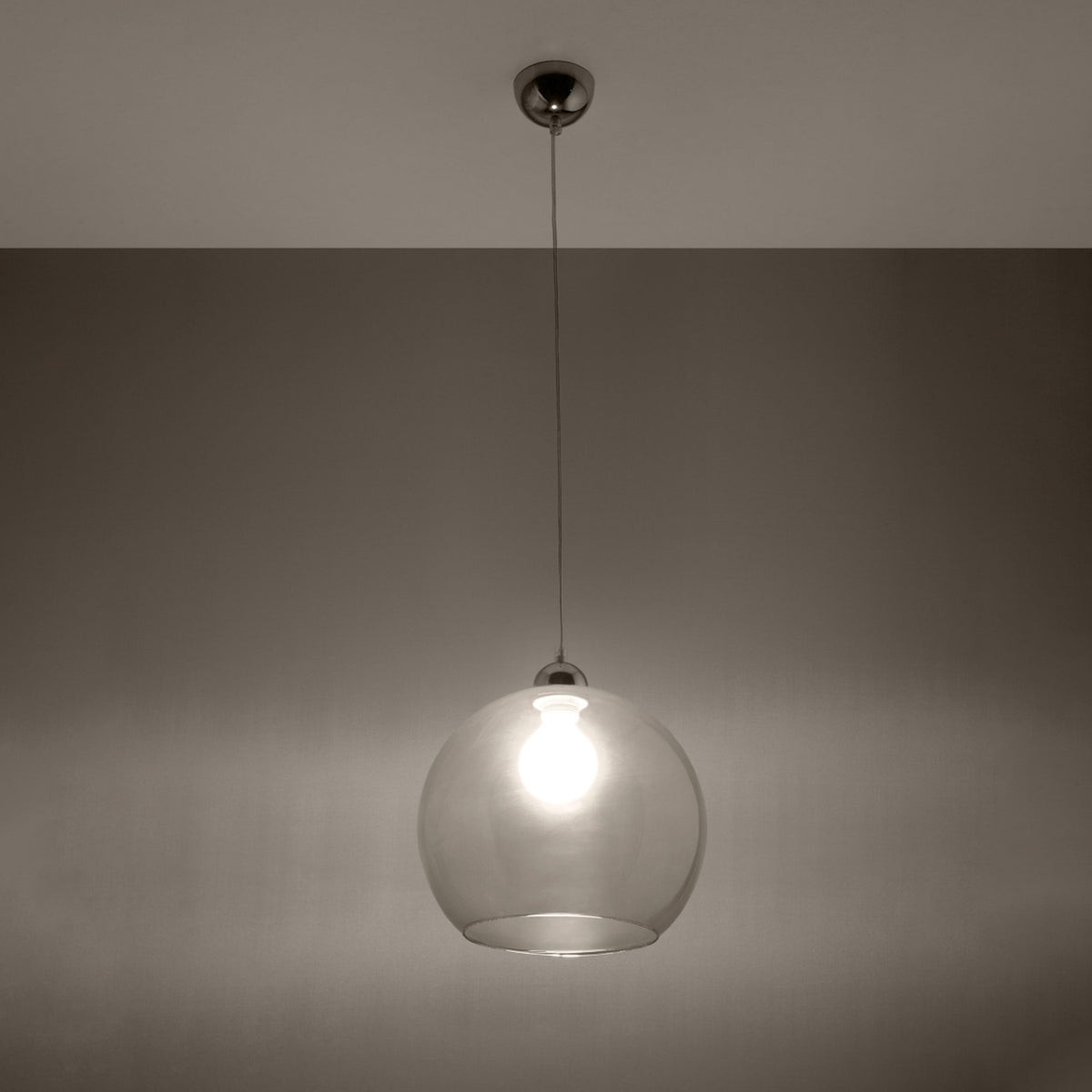 Mise en ambiance nocturne montrant la suspension allumée diffusant une lumière chaude.