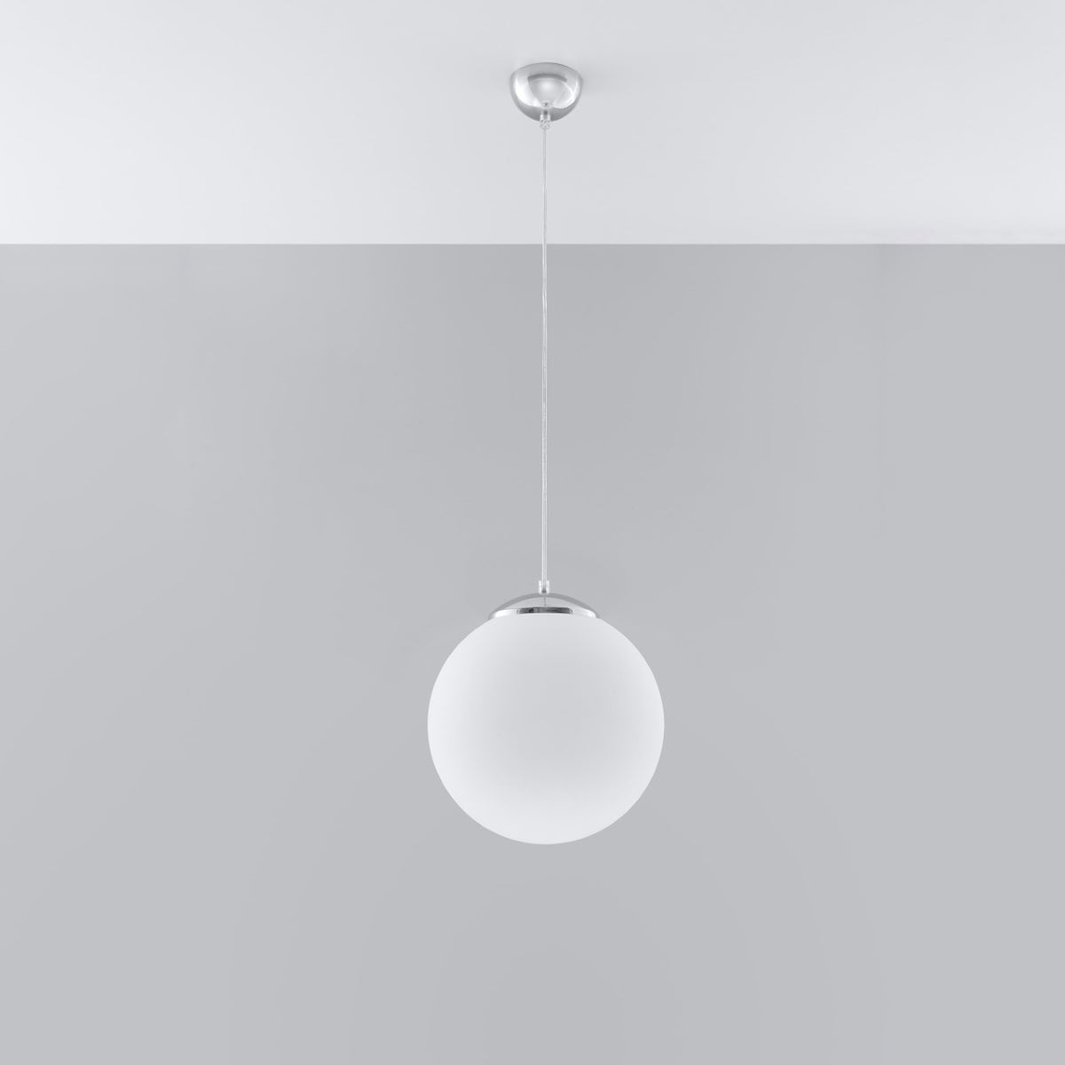 Vue d'ensemble du luminaire suspendu au plafond gris clair, câble fin et boule.