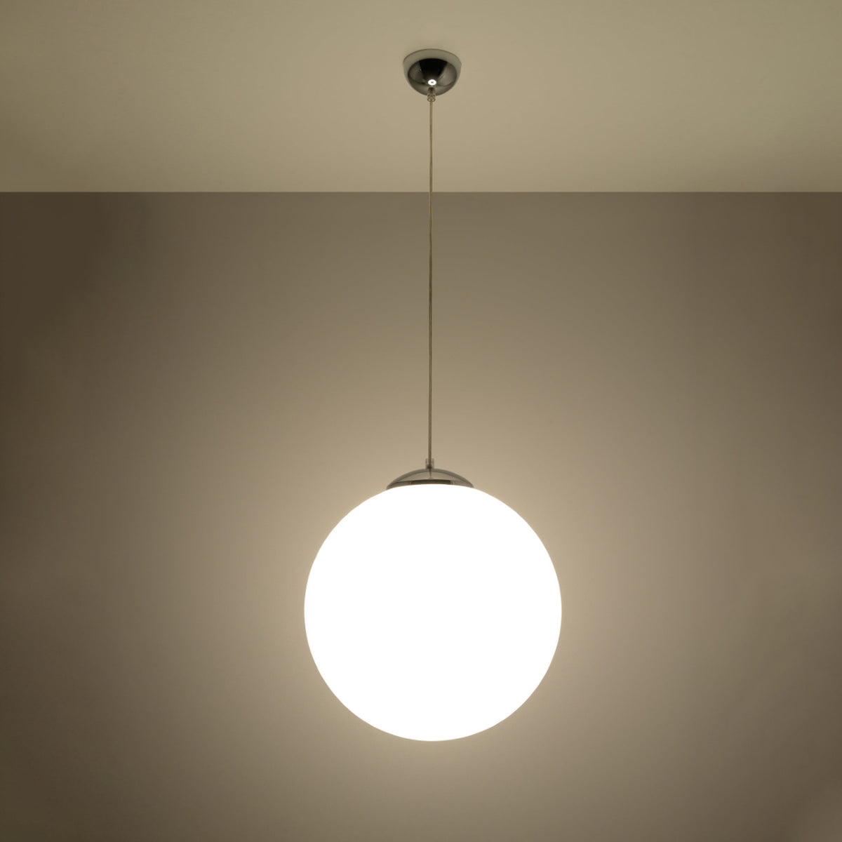 Mise en ambiance nocturne, la sphère lumineuse diffuse une lumière chaude dans une pièce.