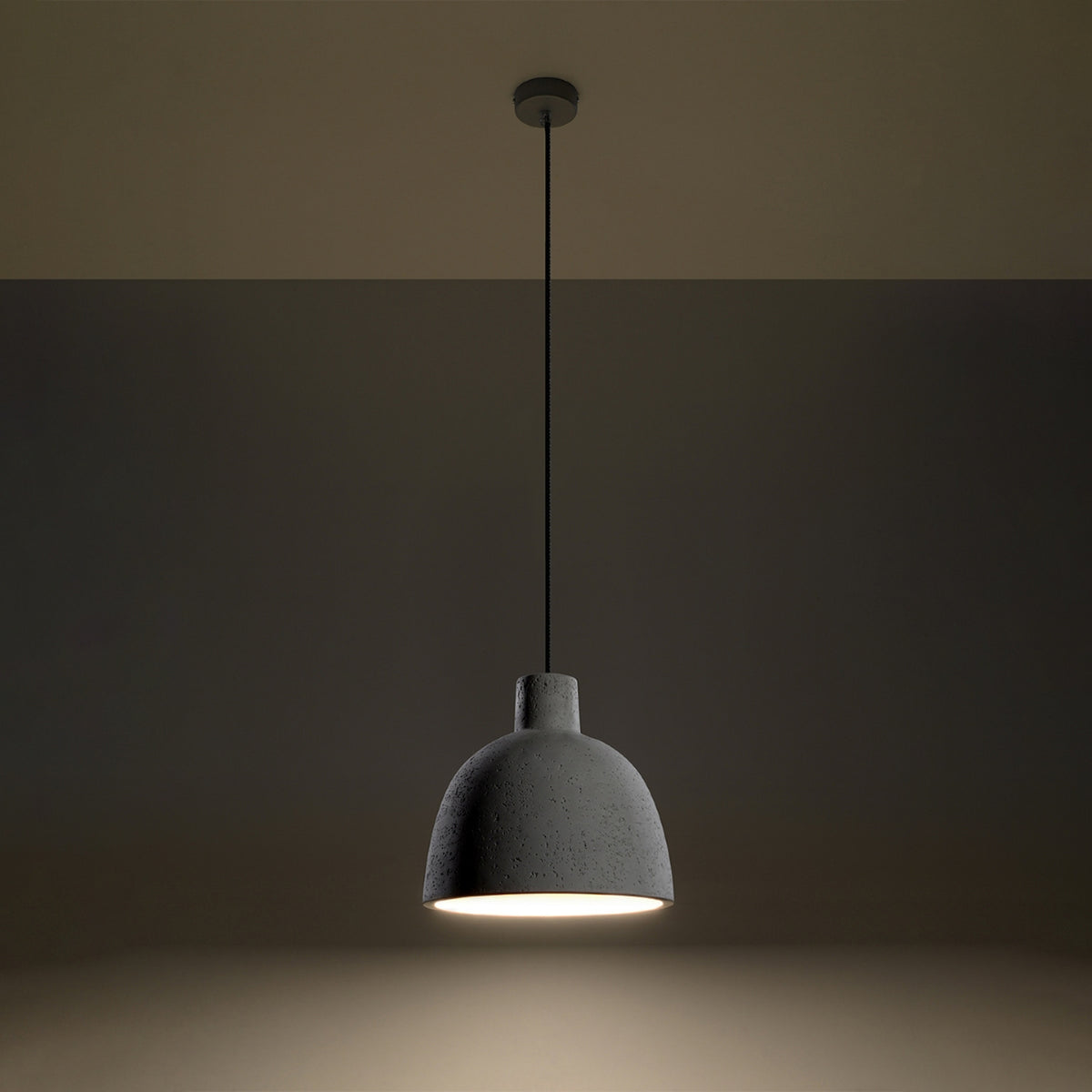 Mise en ambiance nocturne, luminaire suspendu anthracite allumé au-dessus d'un fond sombre