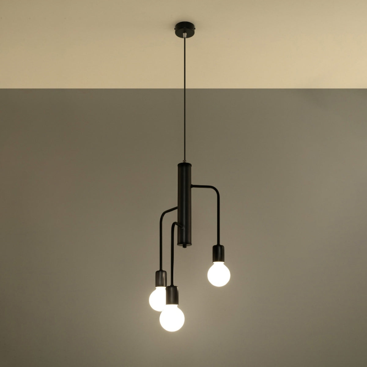 Suspension noire allumée dans une pièce sombre, ampoules blanches diffusant une lumière chaude.