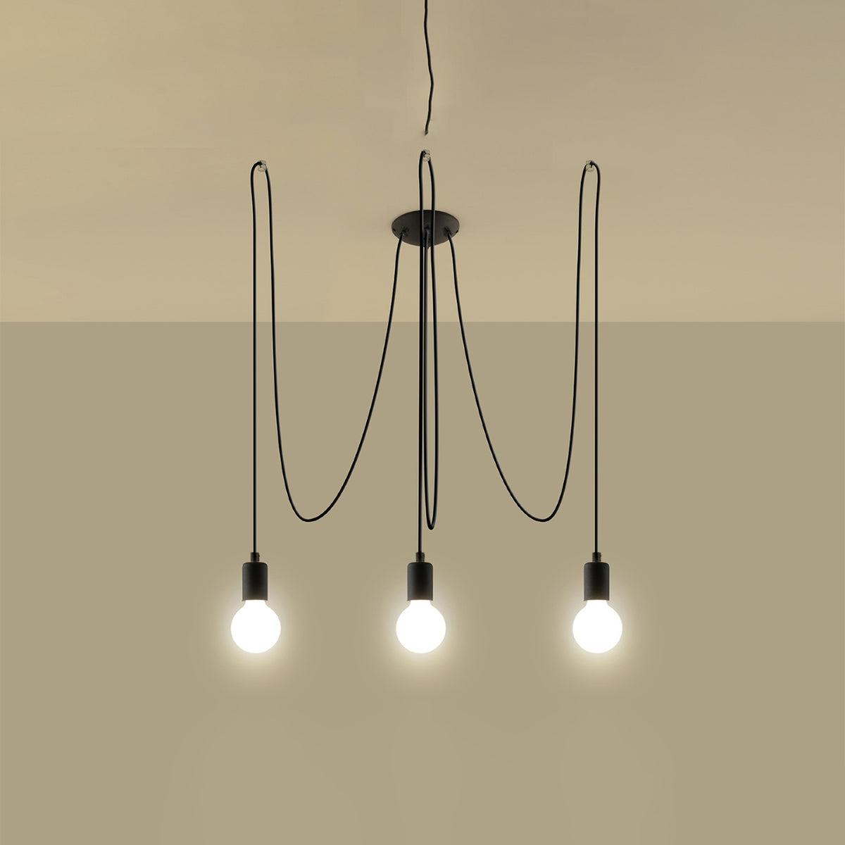 Mise en ambiance beige avec ampoules allumées, suspension noire à trois lumières.