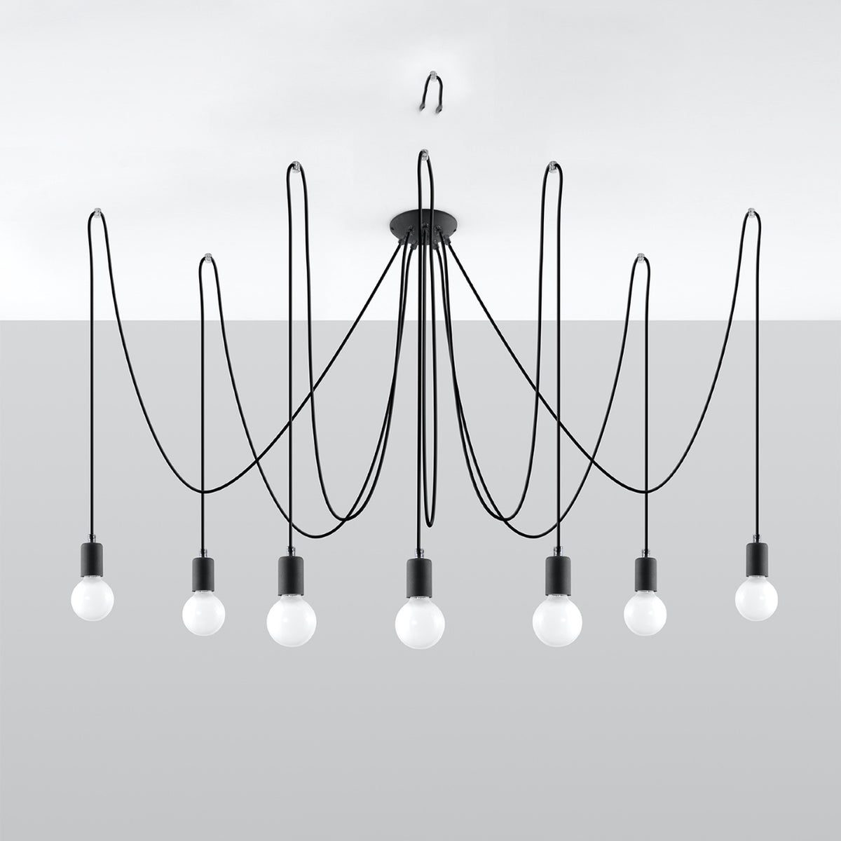 Vue de face du luminaire suspendu sur fond gris, sept douilles noires alignées en bas