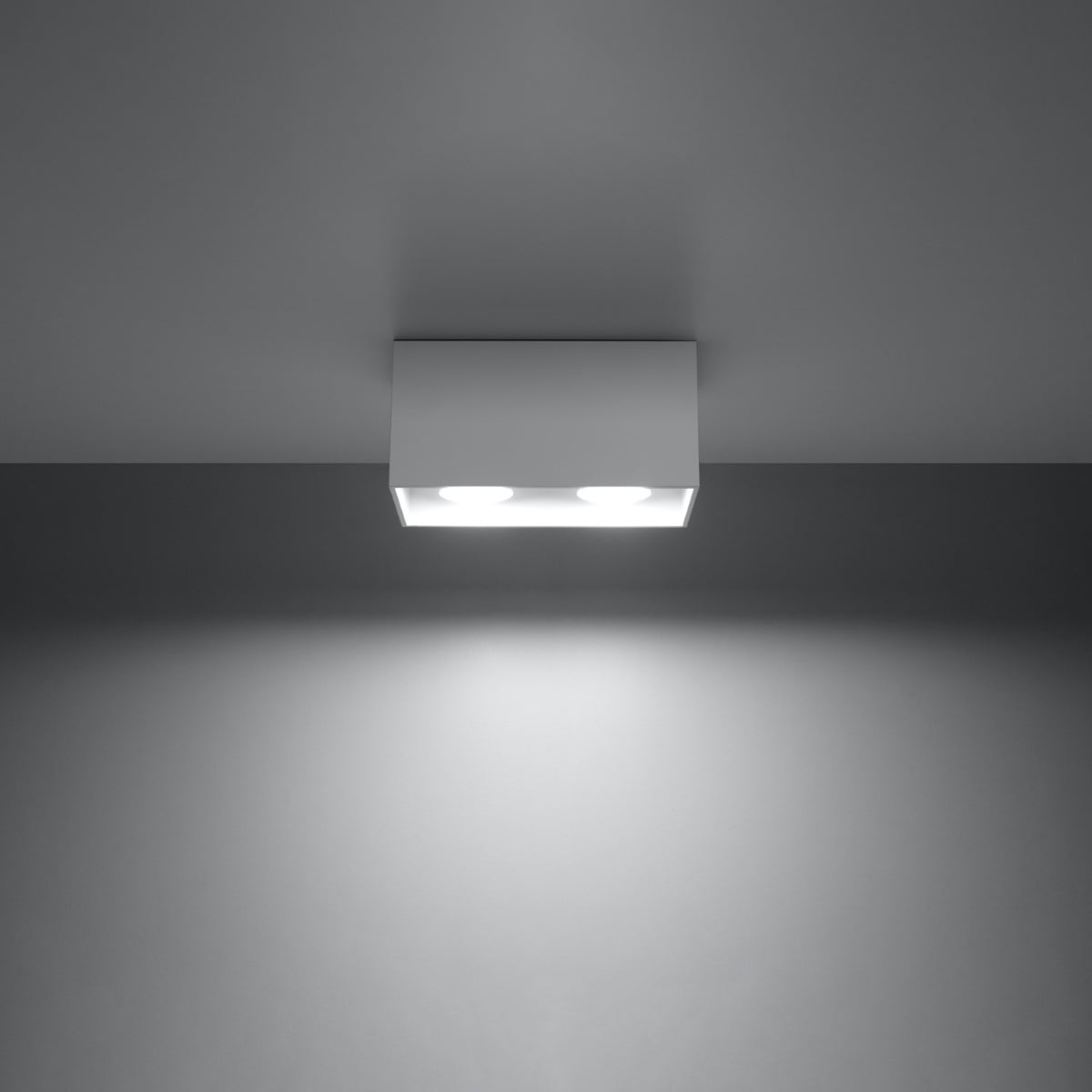 Plafonnier rectangulaire installé au plafond, éclairant une pièce sombre de sa lumière.