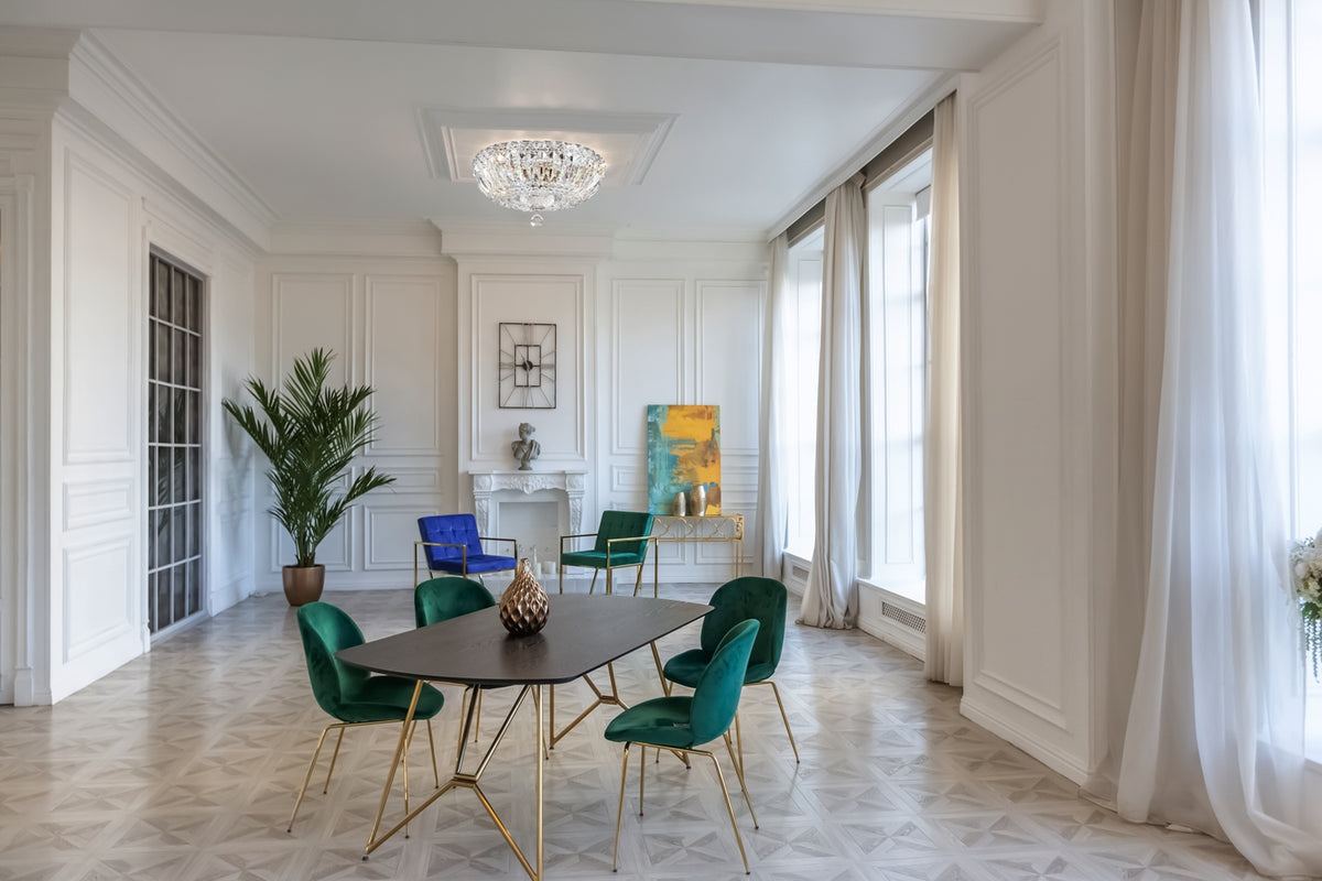 Vue d'ambiance d'une salle à manger blanche où le luminaire cristal est fixé au plafond.
