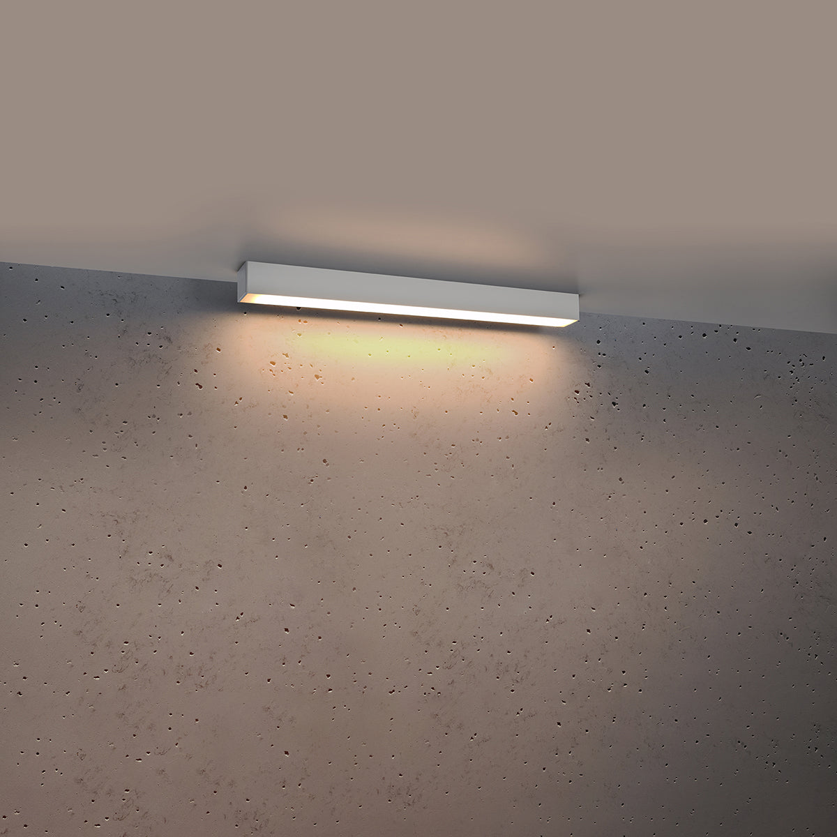 Luminaire allumé diffusant une lumière chaude sur le mur bétonné