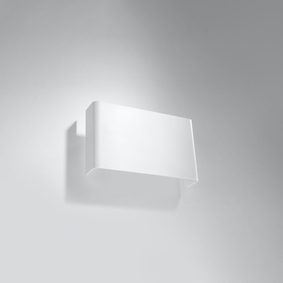 Vue de trois quarts du luminaire fixé au mur, ombre portée douce et discrète.