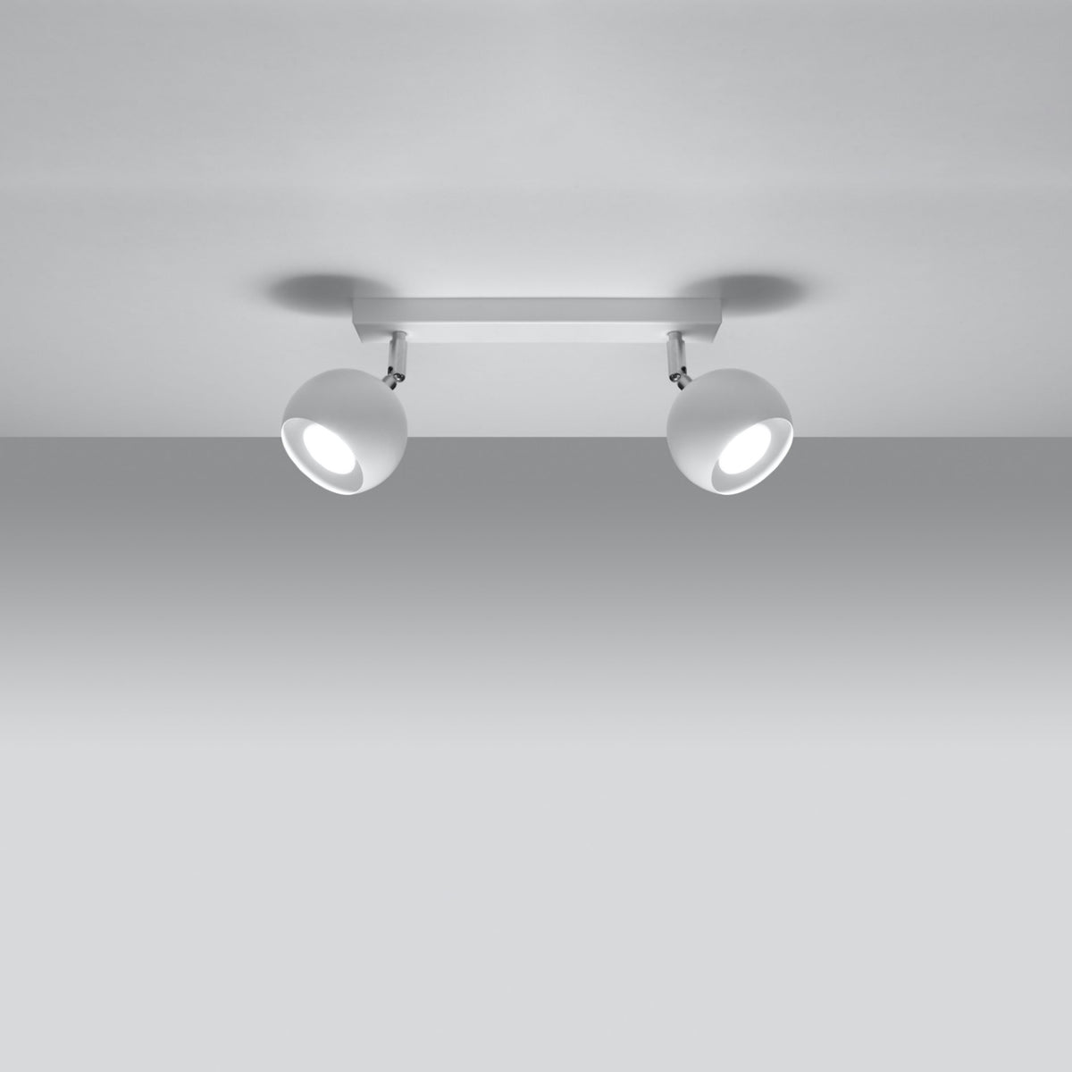 Vue en contre-plongée du plafonnier allumé, halos lumineux sur fond gris