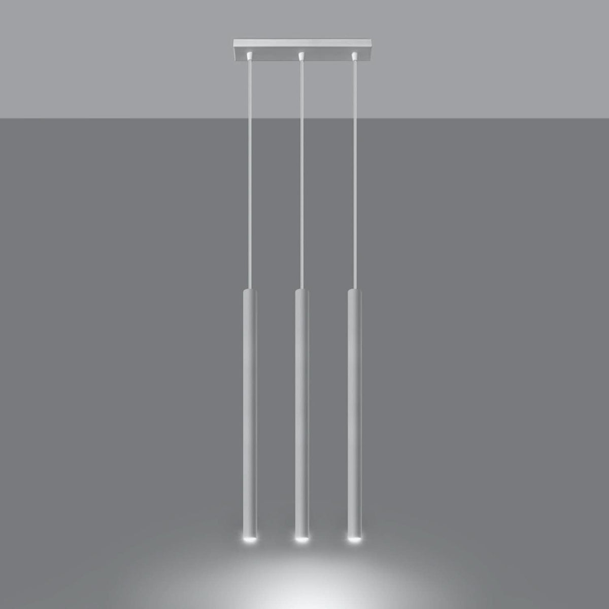 Luminaire suspendu blanc allumé, diffusant une lumière chaude au bas des tubes.