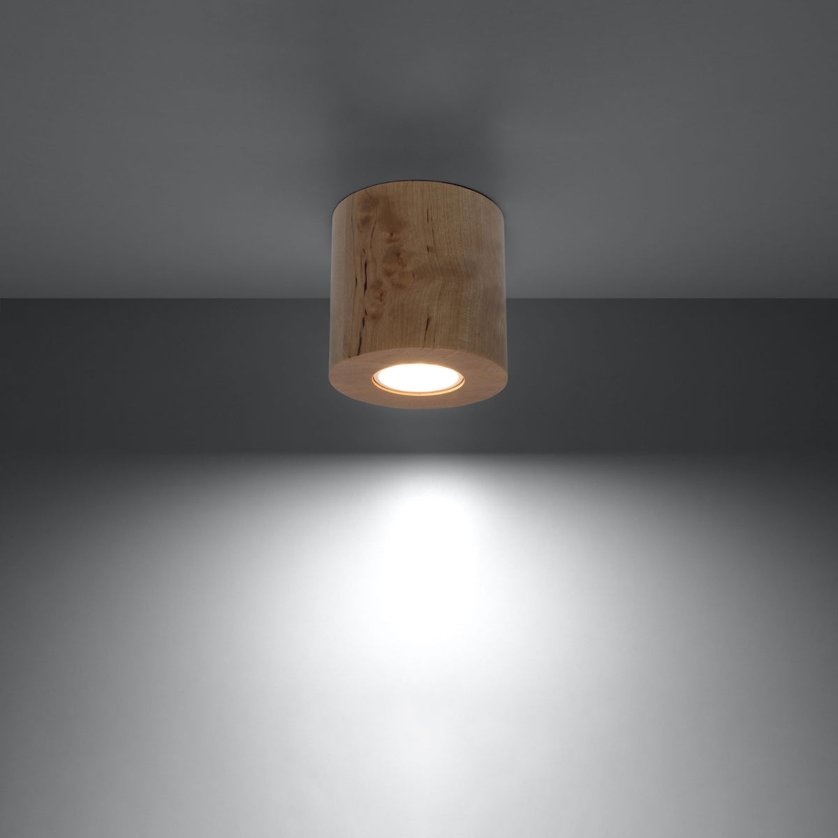 Luminaire allumé dans une pièce sombre projetant un cône de lumière