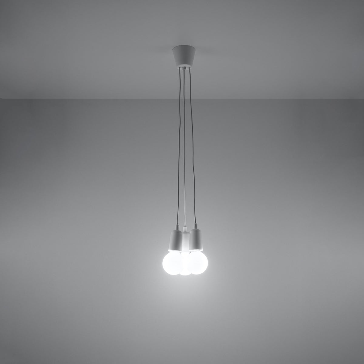 Vue en ambiance sombre de la suspension triple, ses trois ampoules blanches éteintes.
