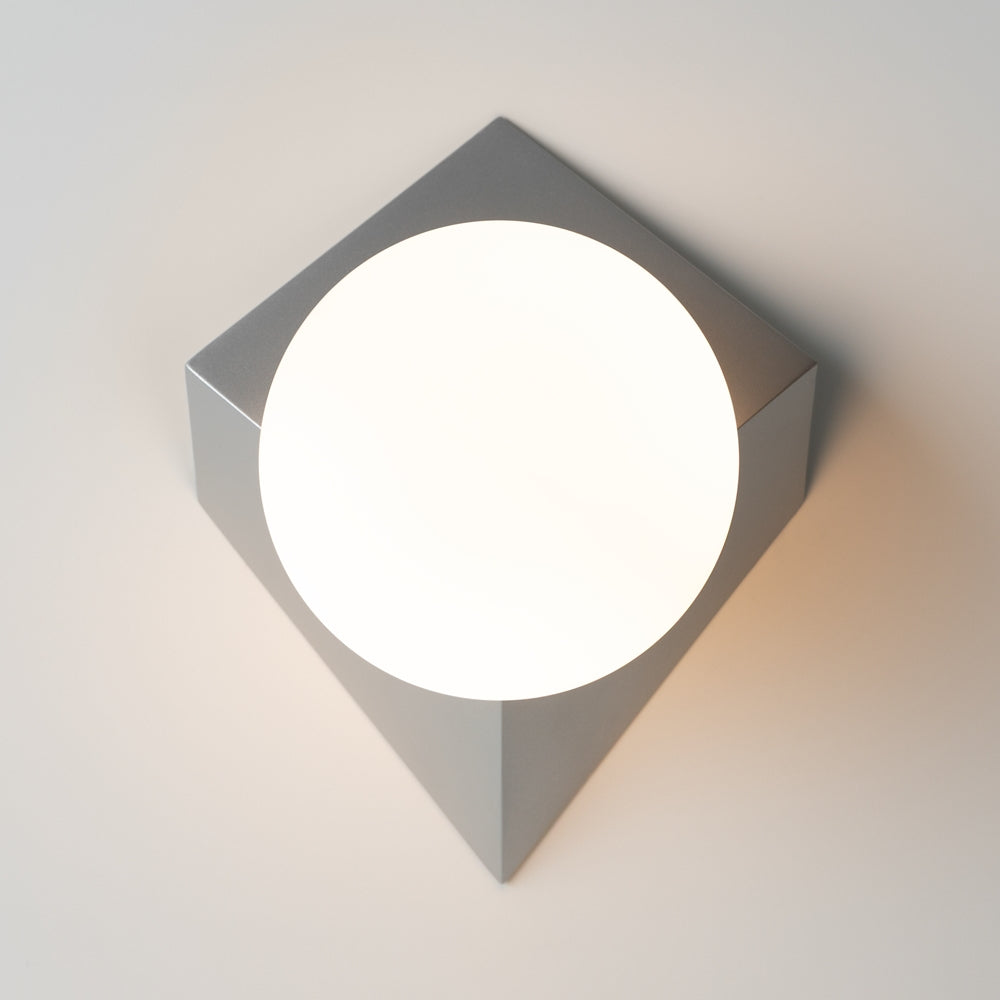 Vue de face du luminaire éclairé, diffuseur rond centré sur platine carrée