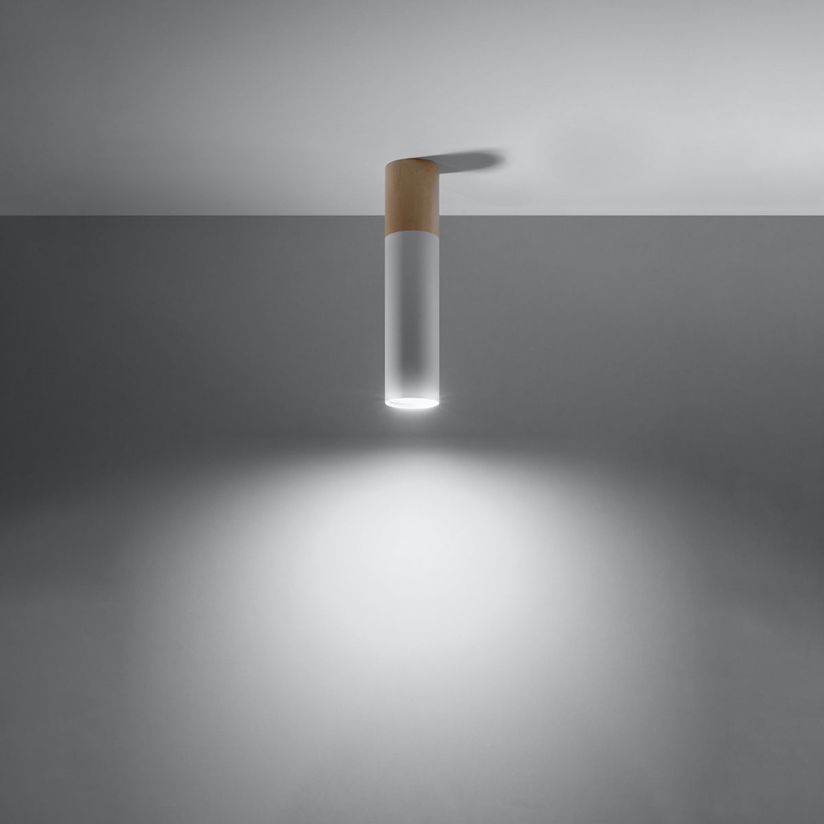 Même luminaire allumé projetant un halo lumineux blanc sur le mur.
