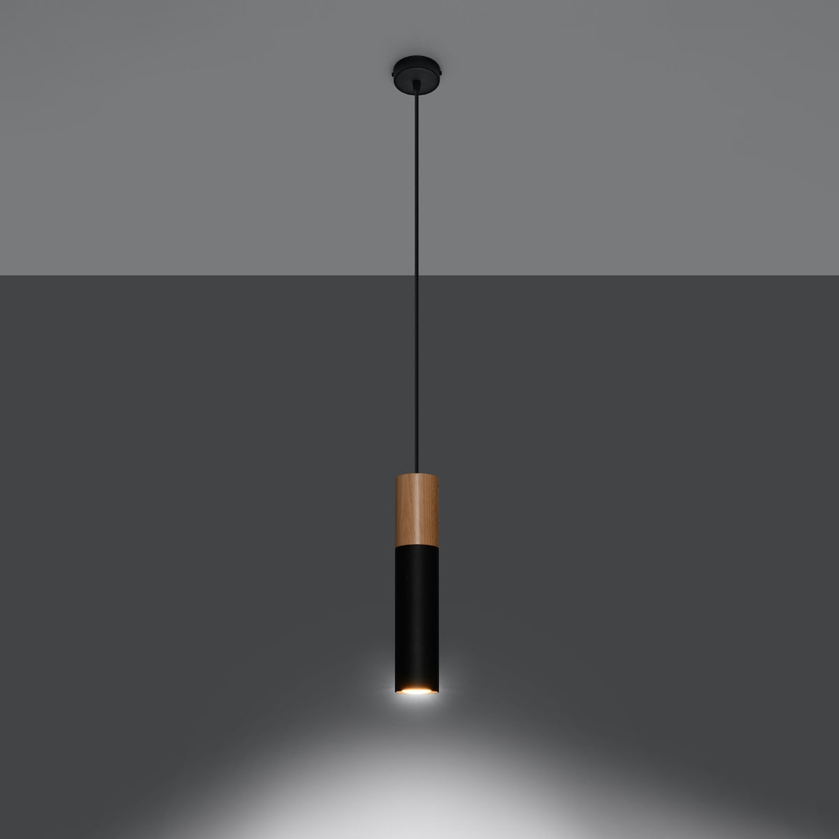 Lampe allumée projetant un halo lumineux vers le bas sur un mur gris.