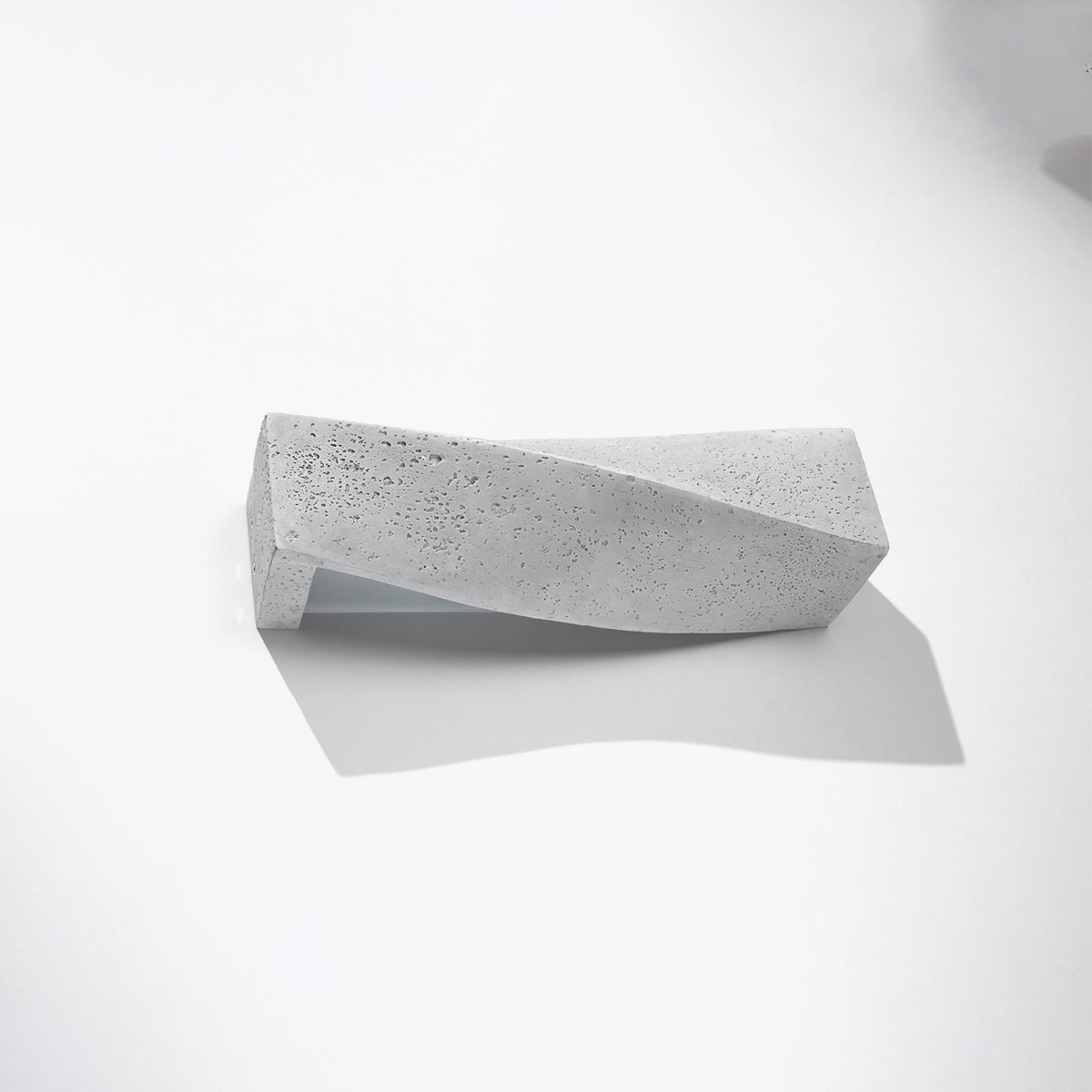 mise en scène du luminaire sur fond blanc, ombre portée douce, texture béton alvéolé