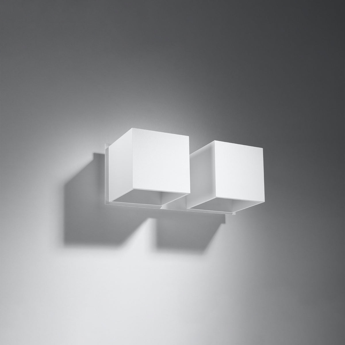 Mise en ambiance de l'applique double sur un mur gris, ombres portées visibles