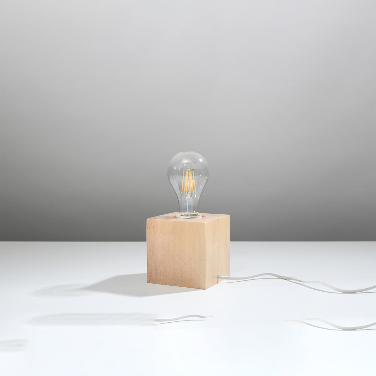Vue de trois quarts de la lampe en bois avec ampoule sur fond gris.