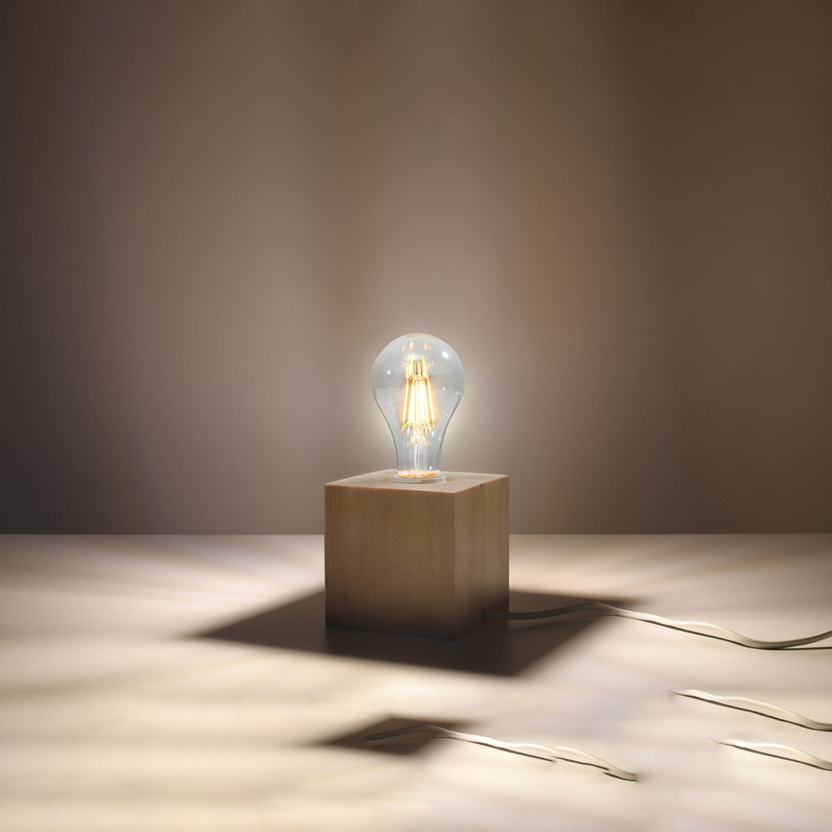 Lampe allumée diffusant une lumière chaude dans une ambiance intérieure sombre.