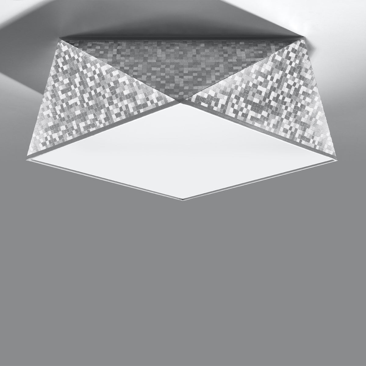 Vue en perspective du luminaire fixé au plafond, montrant ses quatre faces triangulaires