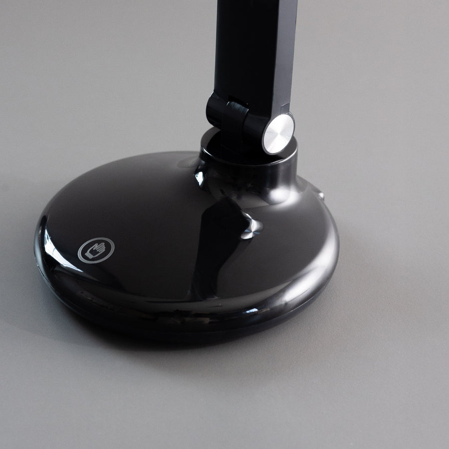 Détail de la base ronde brillante et du bouton tactile de la lampe
