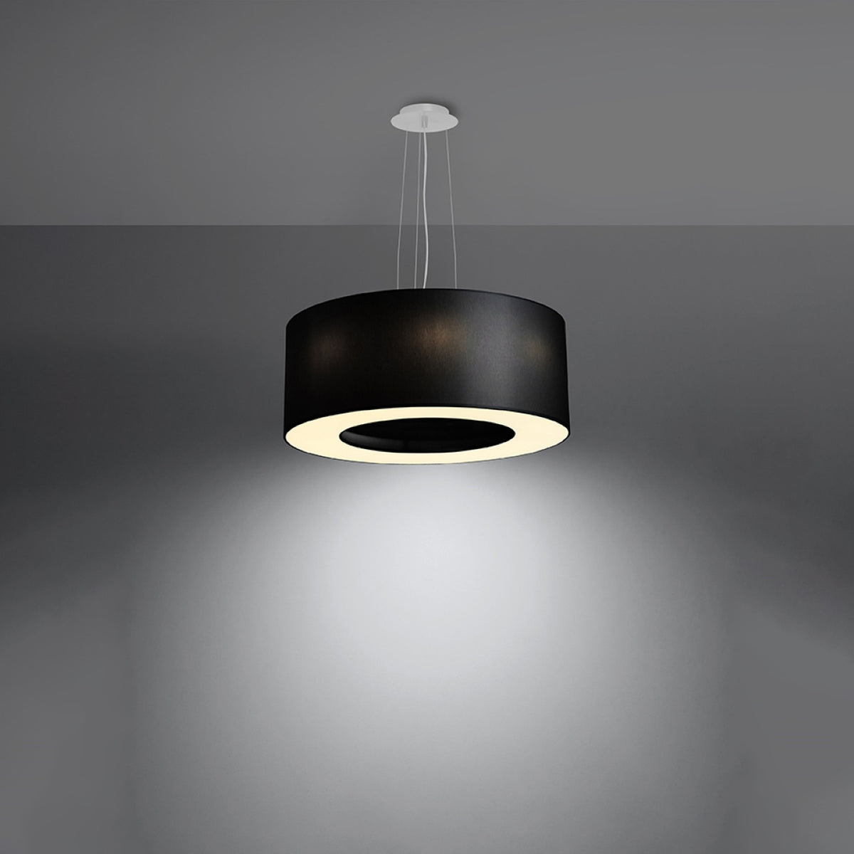 Ambiance nocturne du lustre allumé projetant un large halo lumineux au plafond