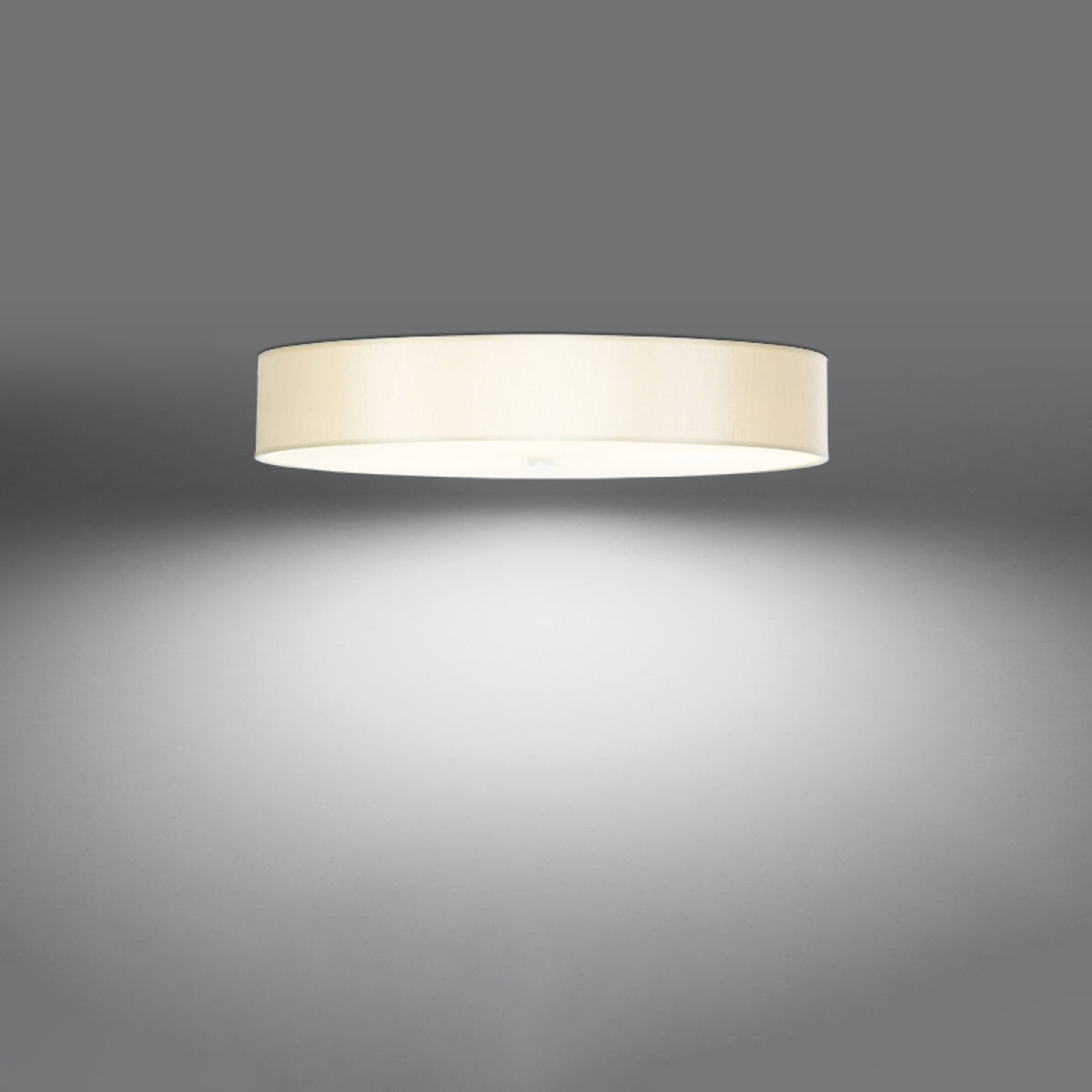 Plafonnier allumé dans une pièce sombre, halo de lumière blanche diffusée