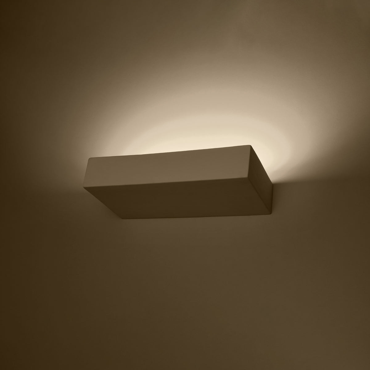 Appliquer allumée dans la pénombre, halo de lumière chaude sur le mur