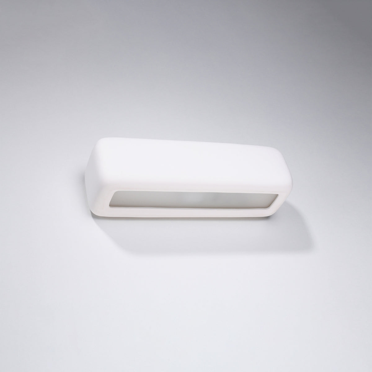Vue trois quarts du luminaire blanc sur fond gris clair, forme galbée aux angles arrondis.