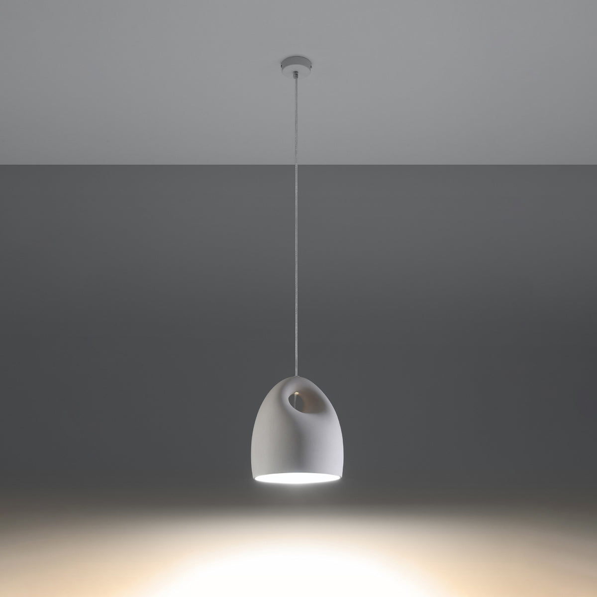 Mise en ambiance sombre montrant le faisceau lumineux projeté au sol par la lampe allumée