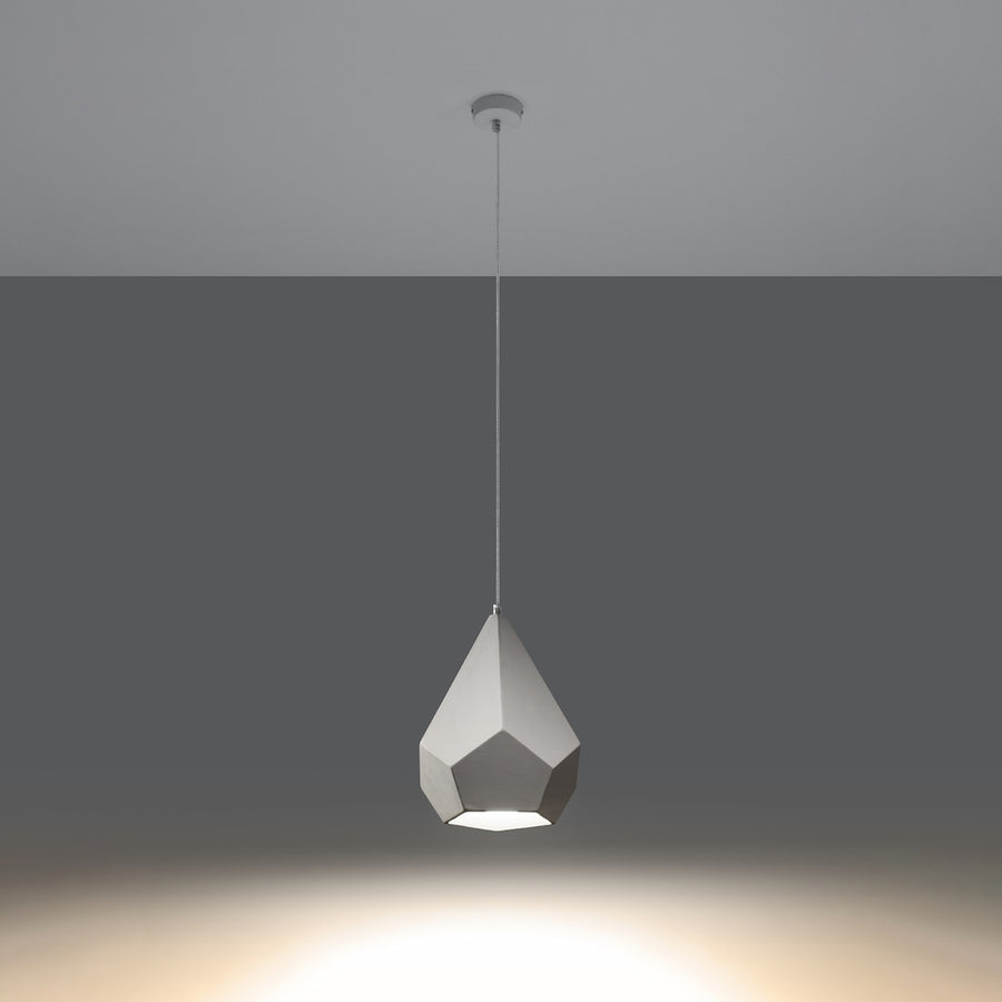 Même suspension céramique blanche allumée, diffusant une lumière chaude vers le sol sombre.