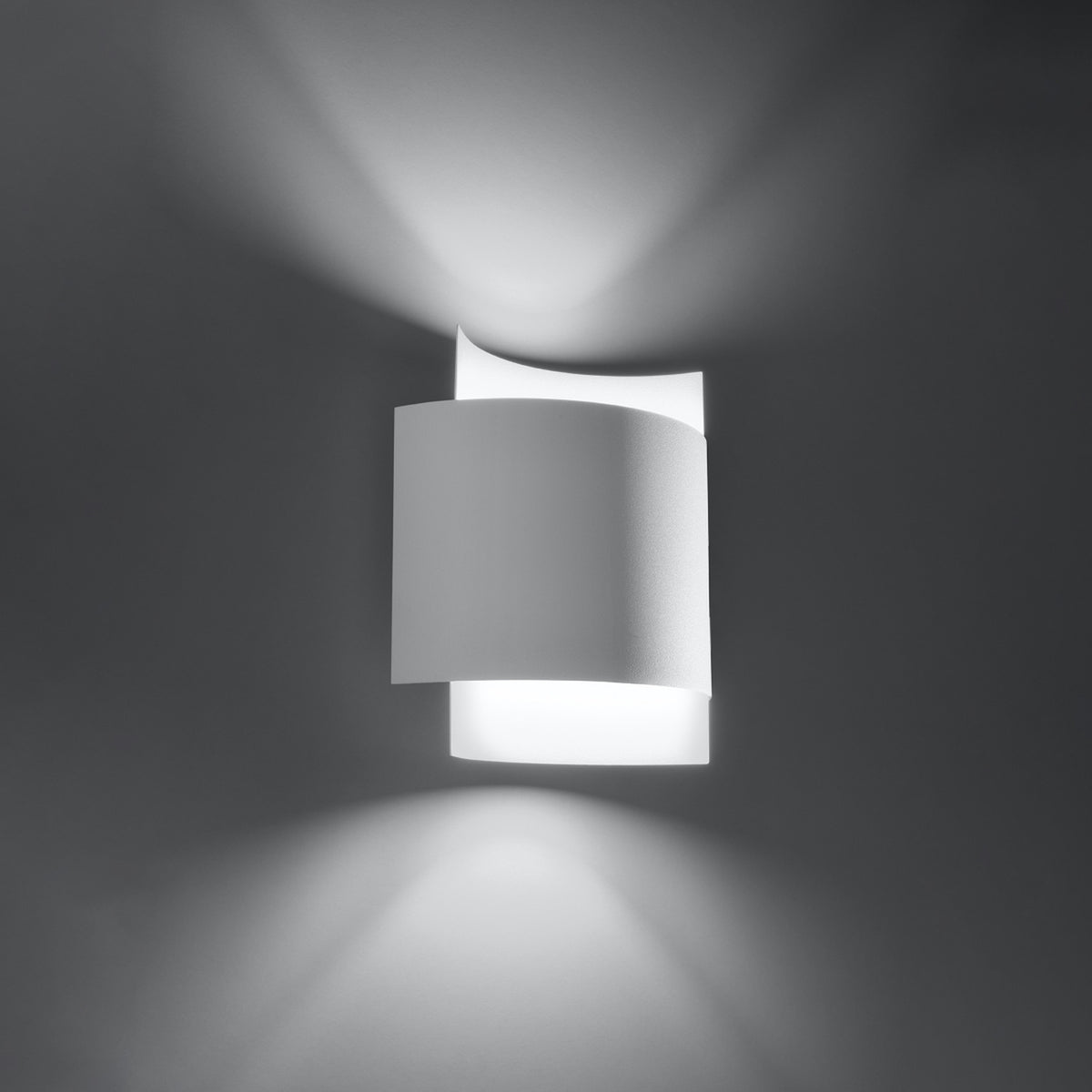 Vue de trois quarts de l'applique allumée, faisceaux lumineux diffusés vers le haut et le bas.