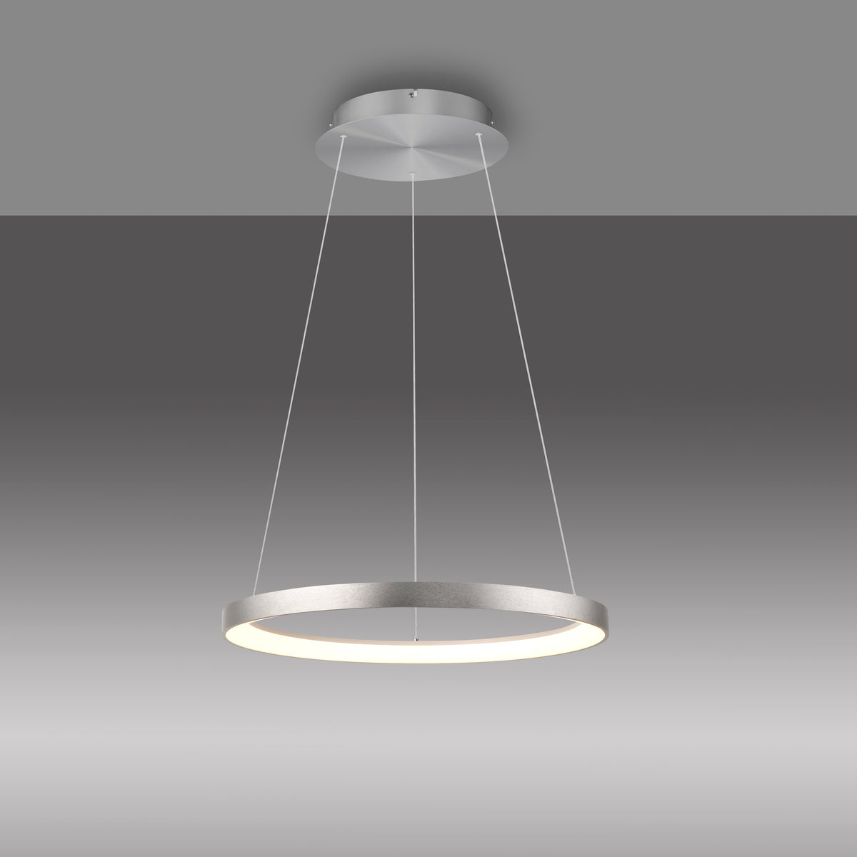 Vue de trois quarts du luminaire suspendu sur dégradé gris, anneau allumé