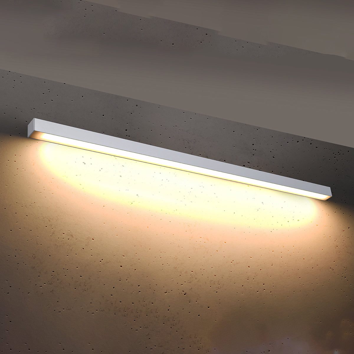Applique allumée projetant une lumière chaude sur un mur en béton brut