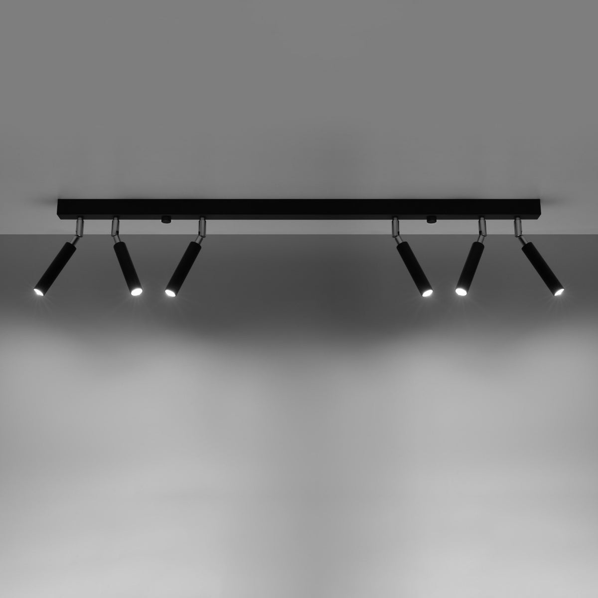 Mise en ambiance sombre avec faisceaux lumineux des six spots dirigés vers le mur.