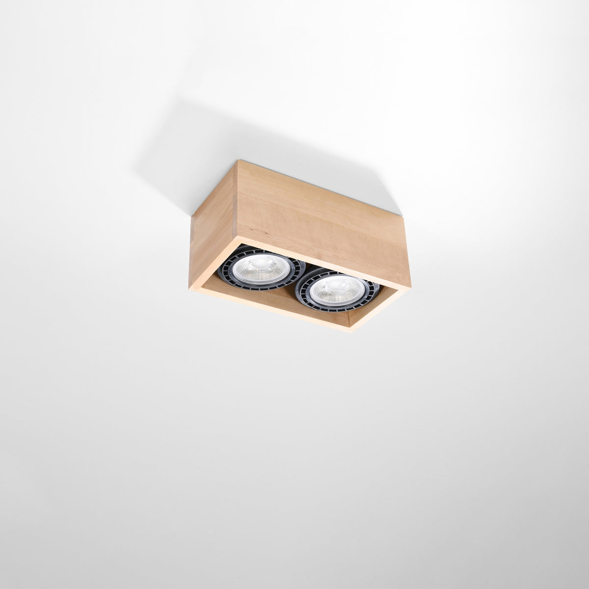 Plafonnier en bois fixé au plafond blanc, éclairant vers le bas avec deux spots.