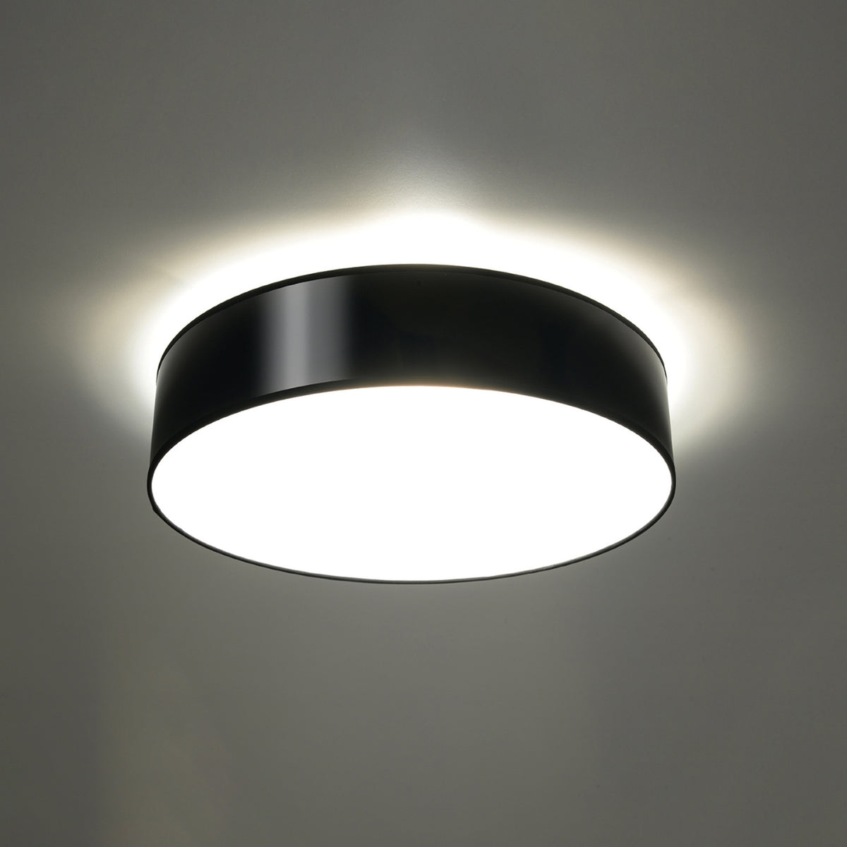Plafonnier allumé au plafond, halo de lumière blanche diffusée autour
