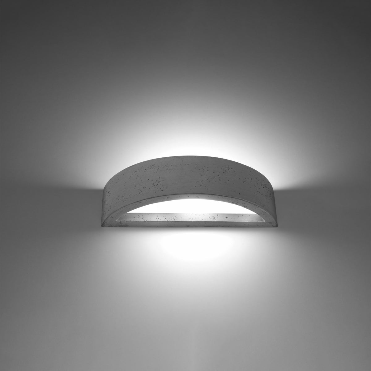 Applique murale allumée dans le noir, halo de lumière diffusé vers le haut et le bas.