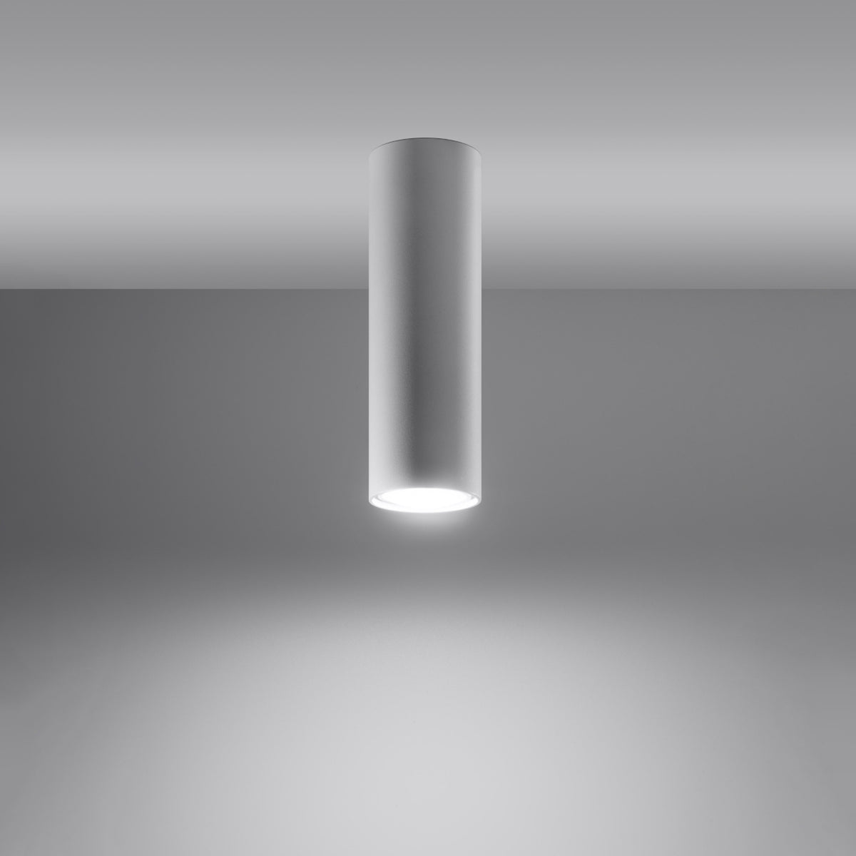 Plafonnier cylindrique blanc allumé, halo lumineux diffusé vers le bas.