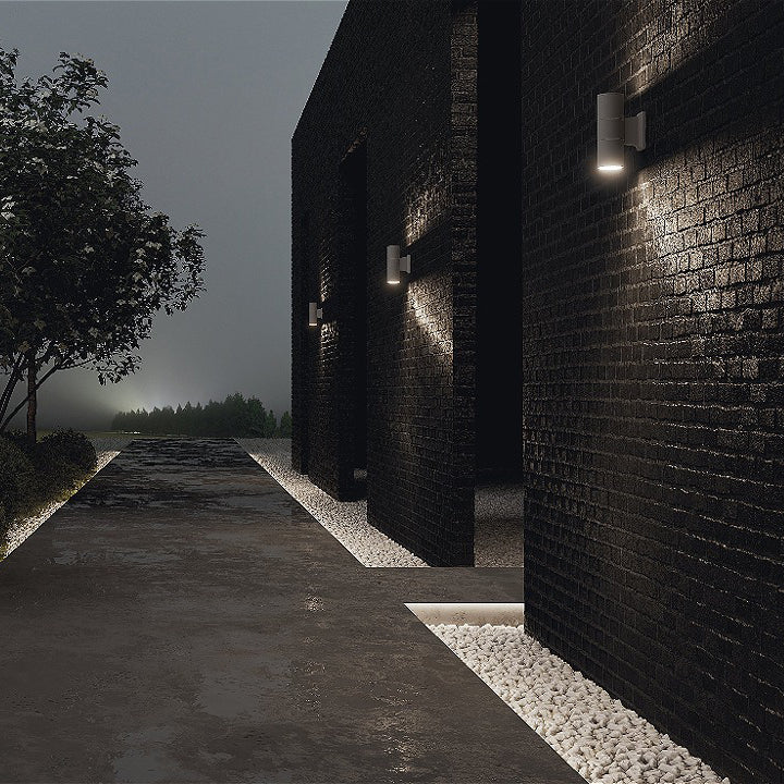 Mise en ambiance nocturne sur une façade de briques noires sous la pluie