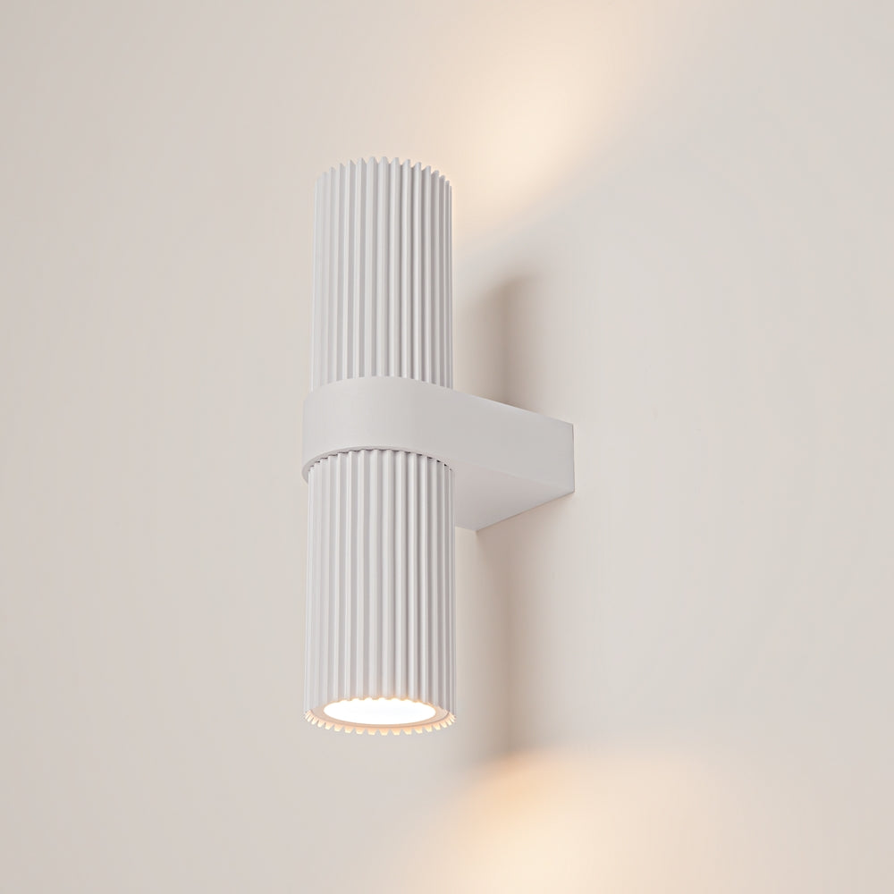 Applique murale blanche allumée, halo lumineux chaud projeté sur le mur