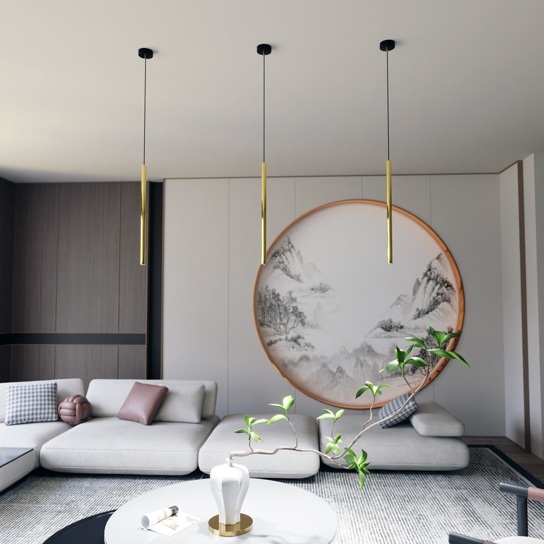 Mise en ambiance dans un salon avec trois suspensions dorées alignées devant une peinture ronde.