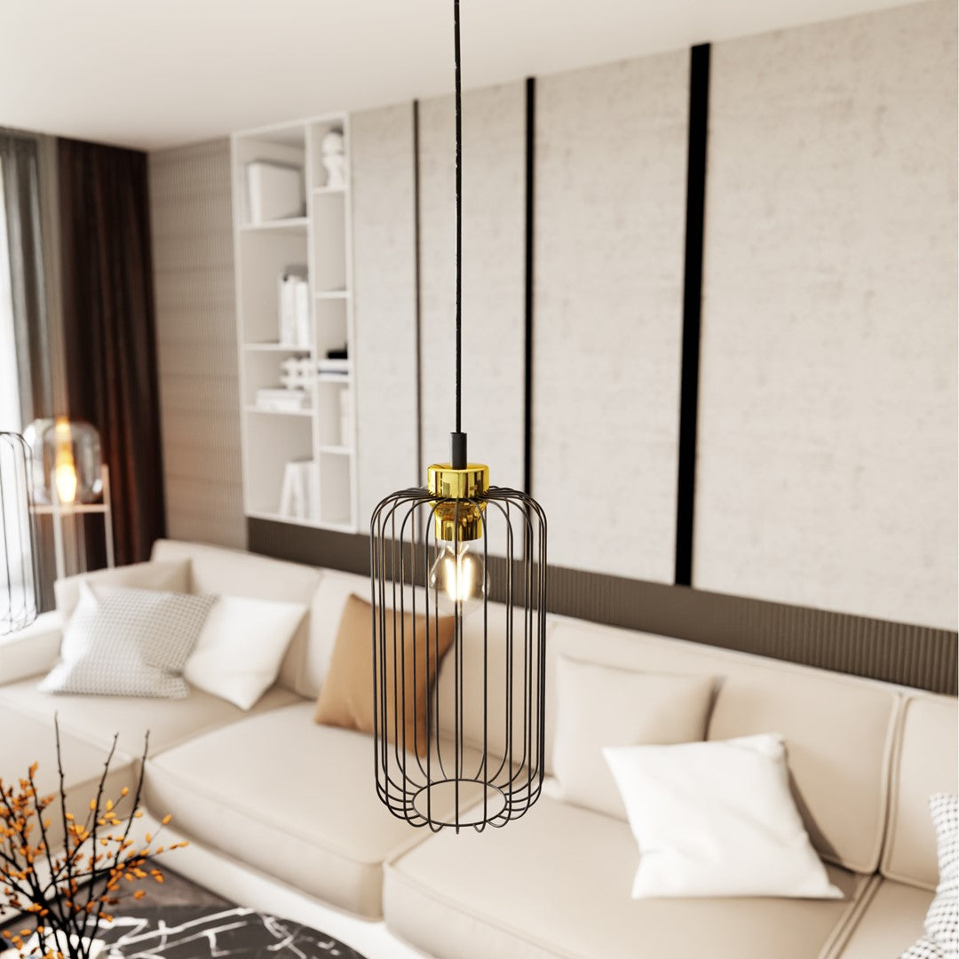 Gros plan sur une suspension cage noire et dorée devant un canapé beige flou.