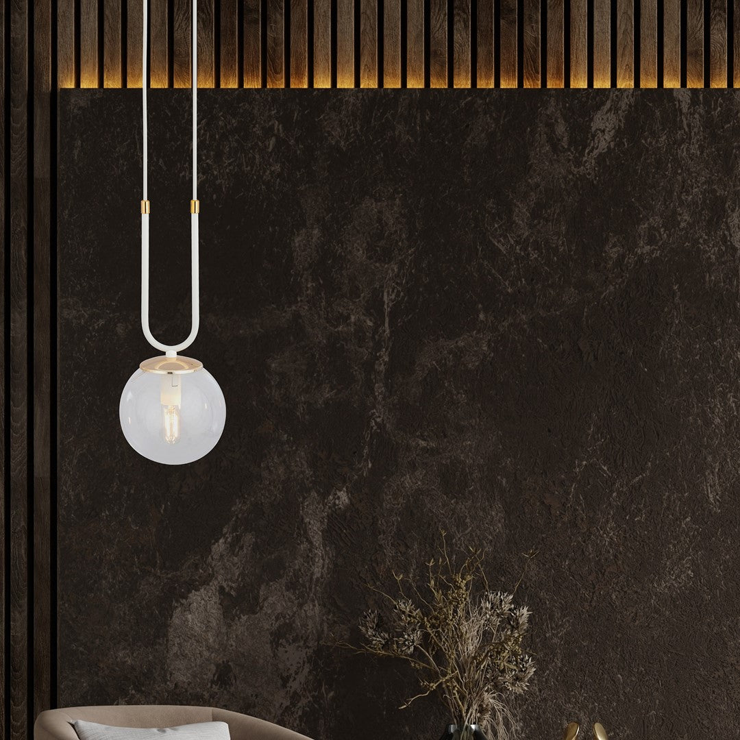 Mise en ambiance sombre avec mur en marbre, tasseaux bois et suspension allumée au-dessus d’un vase.
